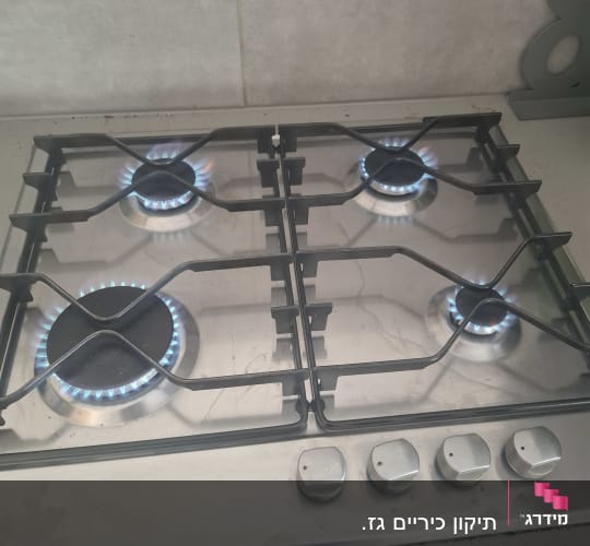 כיריים גז עם ארבעה מבערים דולקים